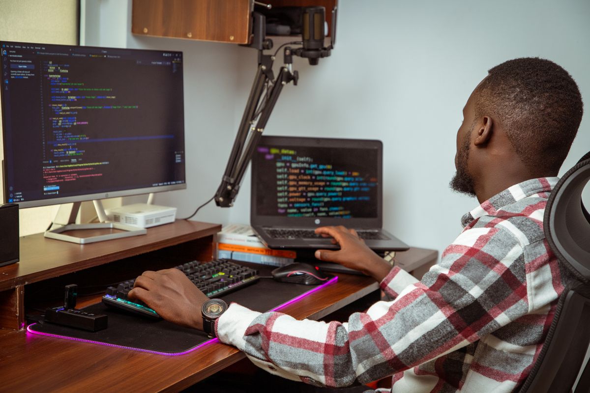 Developer writing code across two screens